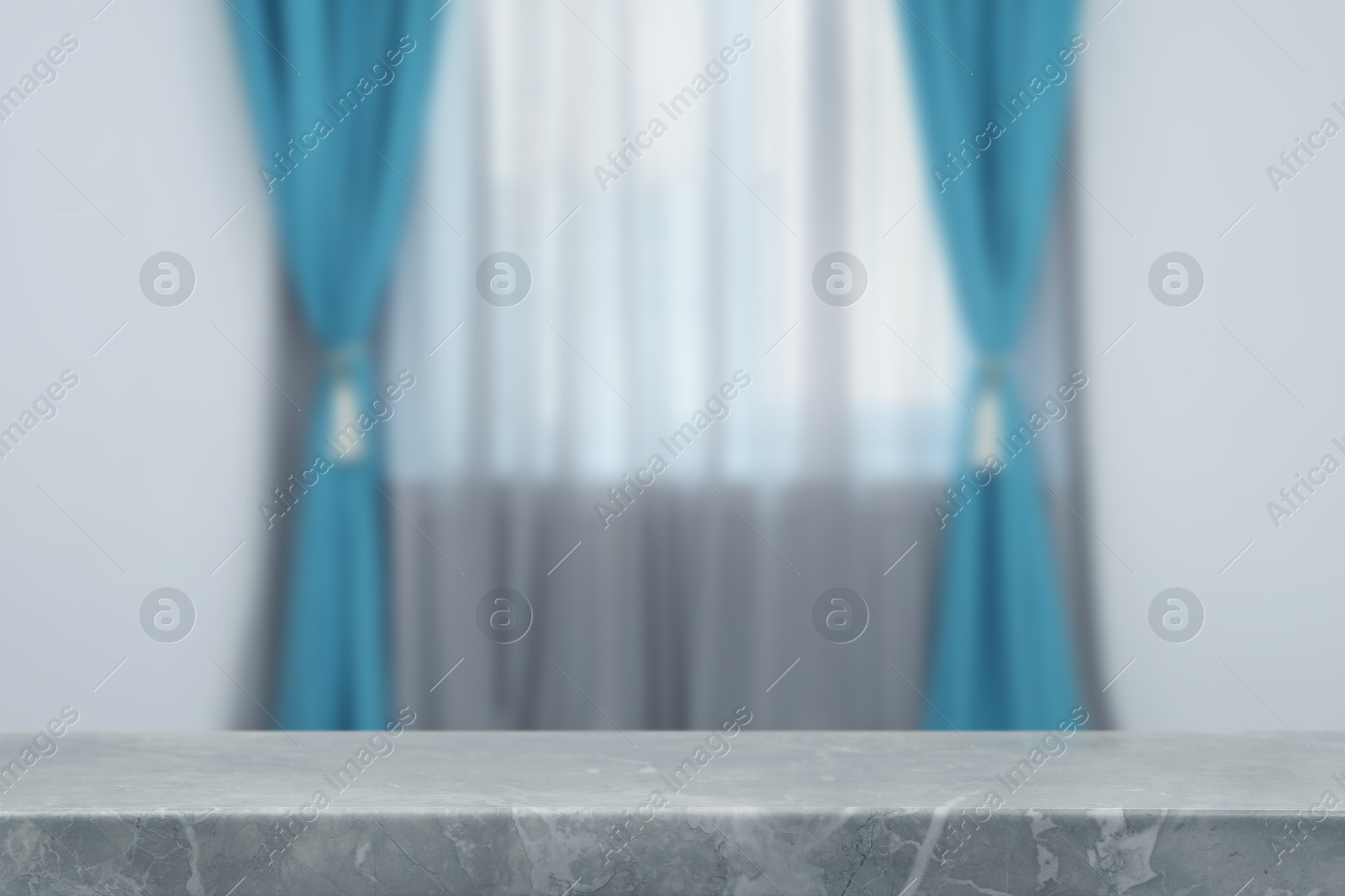 Image of Empty stone table against window with curtains in room