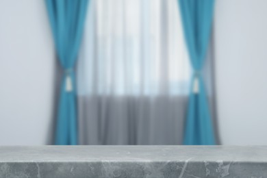 Image of Empty stone table against window with curtains in room