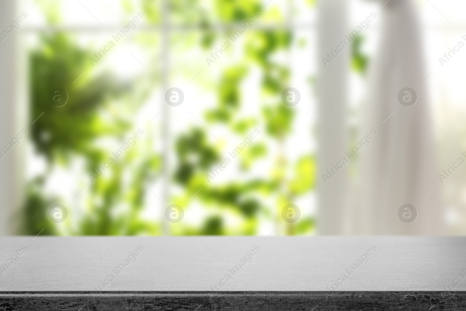 Image of Empty stone table against window with curtain in room
