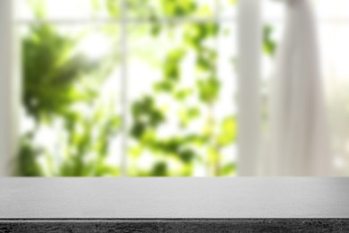 Image of Empty stone table against window with curtain in room