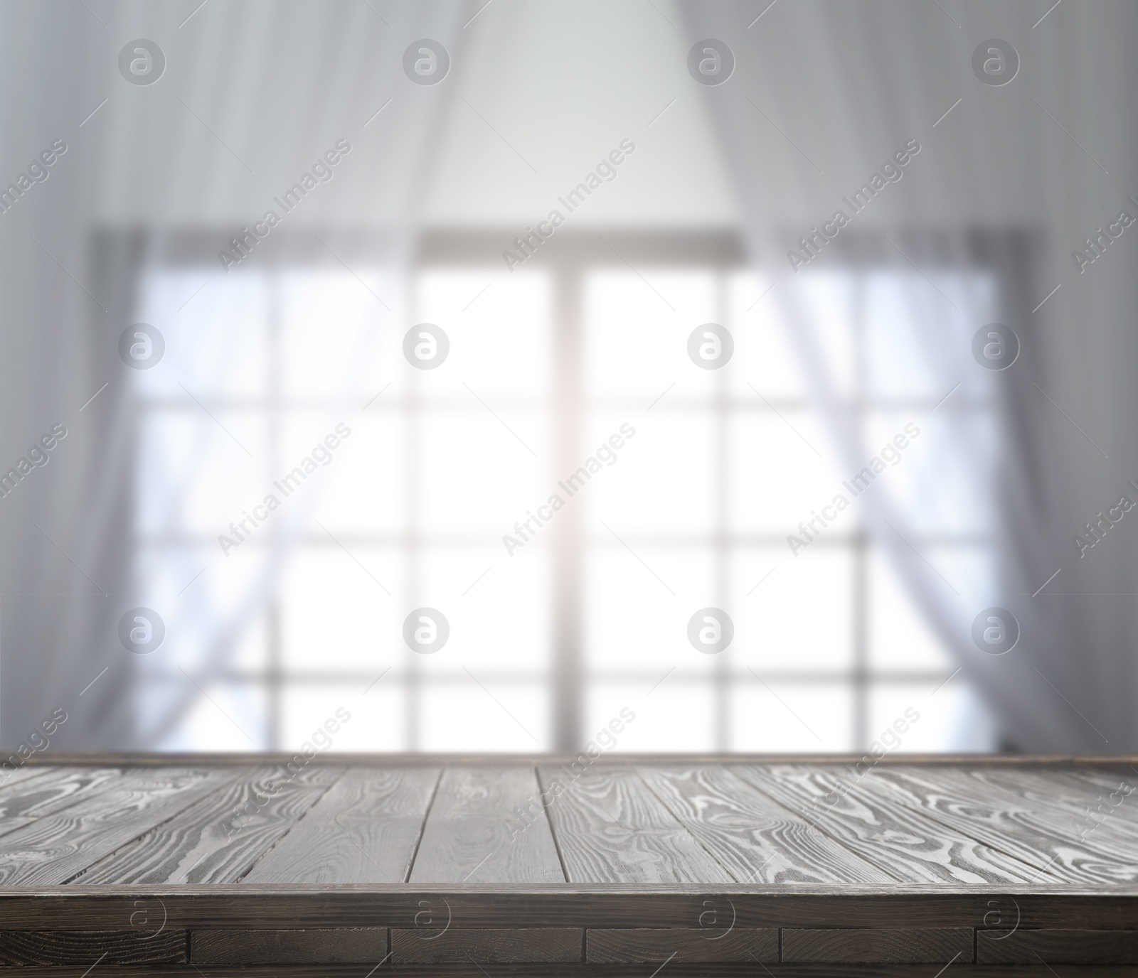 Image of Empty wooden table against window with curtains in room
