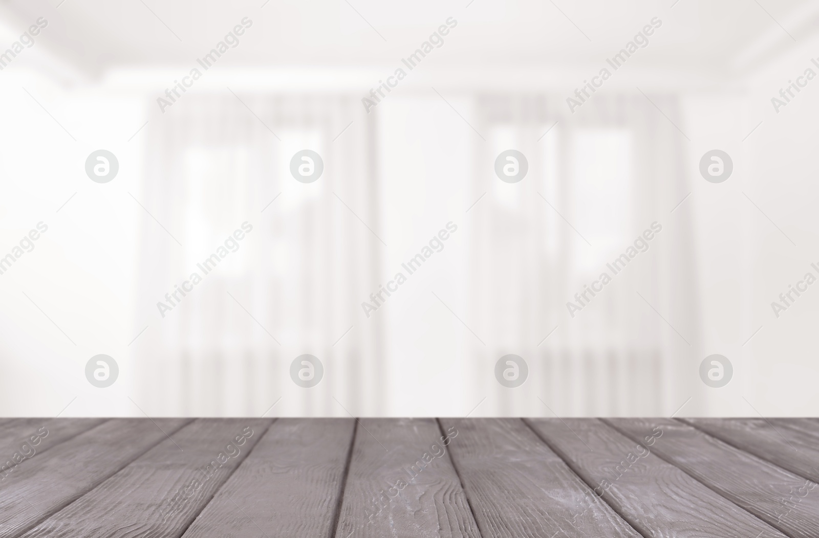 Empty wooden table against windows with curtains in room Image of Empty wooden table against windows with curtains in room