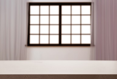 Image of Empty table against window with curtains in room