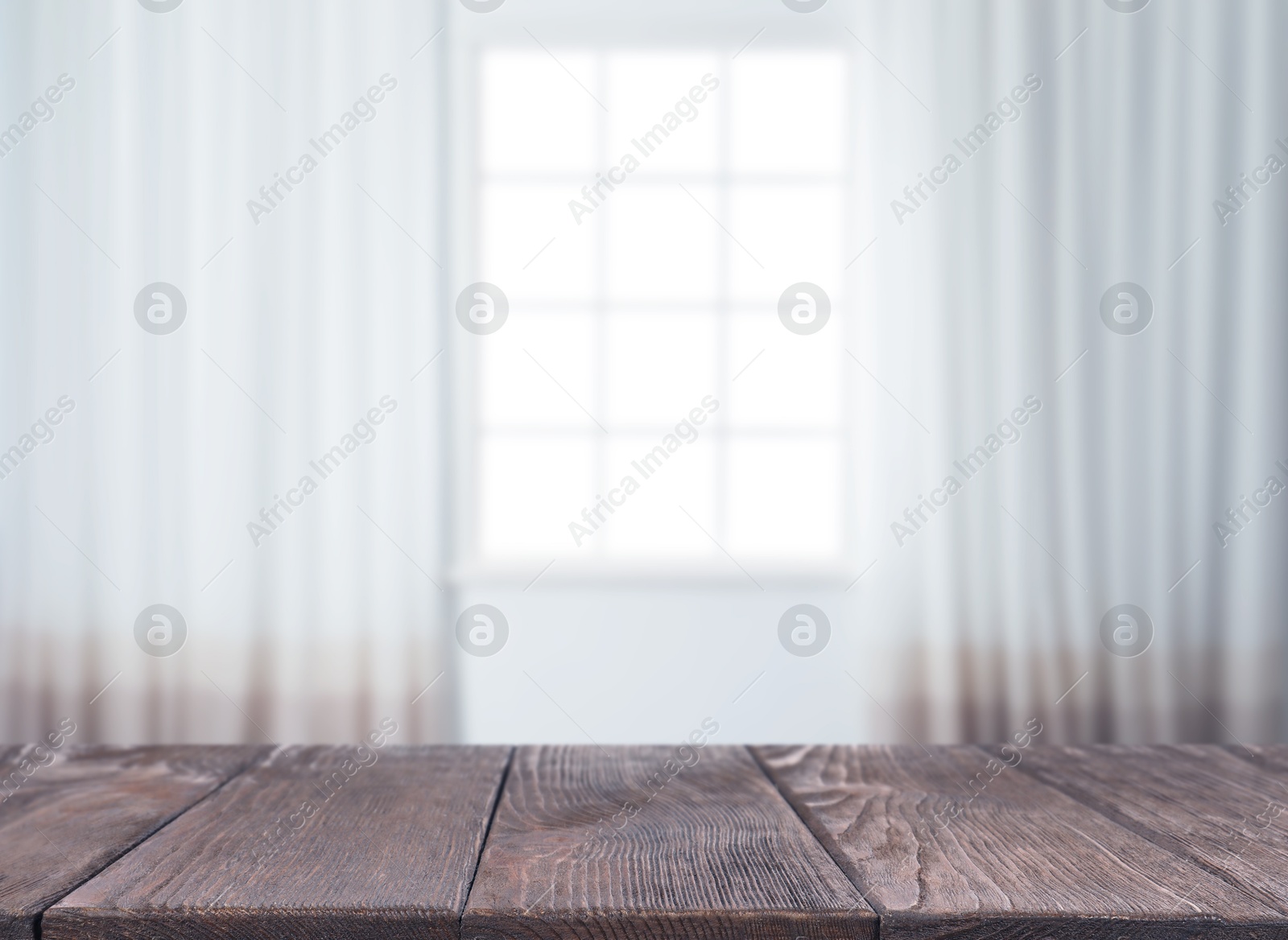 Image of Empty wooden table against window with curtains in room