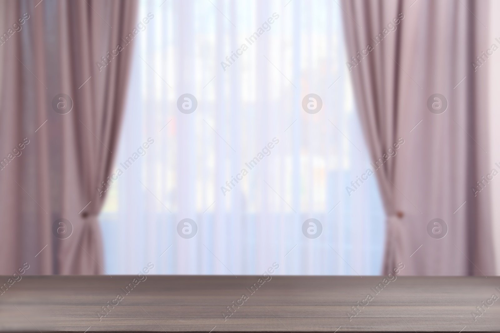 Image of Empty wooden table against window with curtains in room