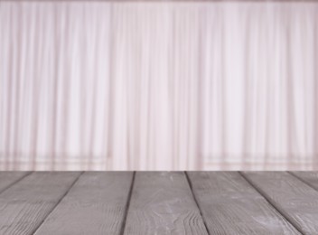Image of Empty wooden table against window with curtains in room