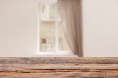 Image of Empty wooden table against window with curtain in room