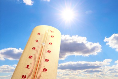 Image of High temperature on thermometer against sky on sunny day