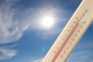 Image of Extremely high temperature on thermometer against blue sky on sunny day. Summer weather