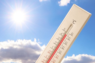 Image of Extremely high temperature on thermometer against blue sky on sunny day. Summer weather