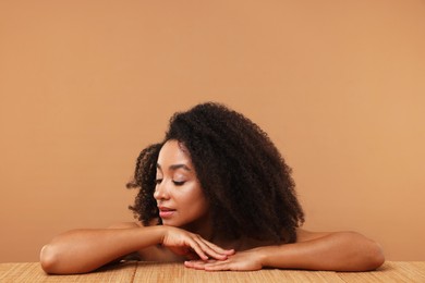 Photo of Portrait of beautiful Brazilian woman after spa treatment at bamboo table on beige background