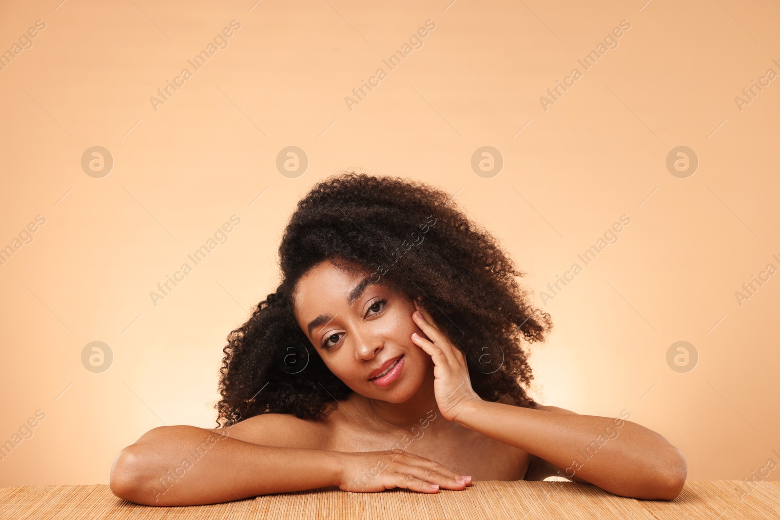 Portrait of beautiful Brazilian woman after spa treatment at bamboo table on beige gradient background Photo of Portrait of beautiful Brazilian woman after spa treatment at bamboo table on beige gradient background