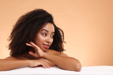 Photo of Portrait of beautiful Brazilian woman with towel after spa treatment on beige gradient background. Space for text