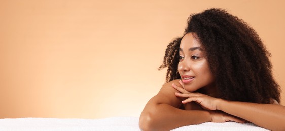 Photo of Portrait of beautiful Brazilian woman with towel after spa treatment on beige gradient background. Space for text