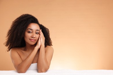 Photo of Portrait of beautiful Brazilian woman with towel after spa treatment on beige gradient background. Space for text