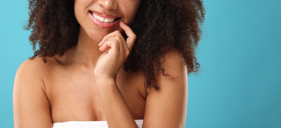 Photo of Brazilian woman after spa treatment on light blue background, closeup. Space for text