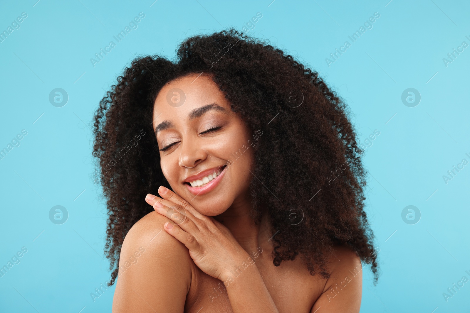 Portrait of beautiful Brazilian woman after spa treatment on light blue background Photo of Portrait of beautiful Brazilian woman after spa treatment on light blue background