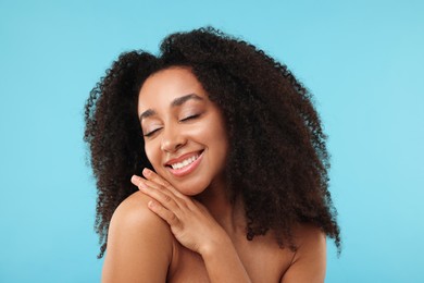 Photo of Portrait of beautiful Brazilian woman after spa treatment on light blue background