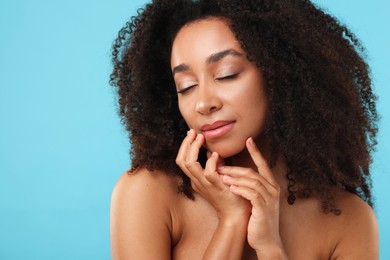 Photo of Portrait of beautiful Brazilian woman after spa treatment on light blue background