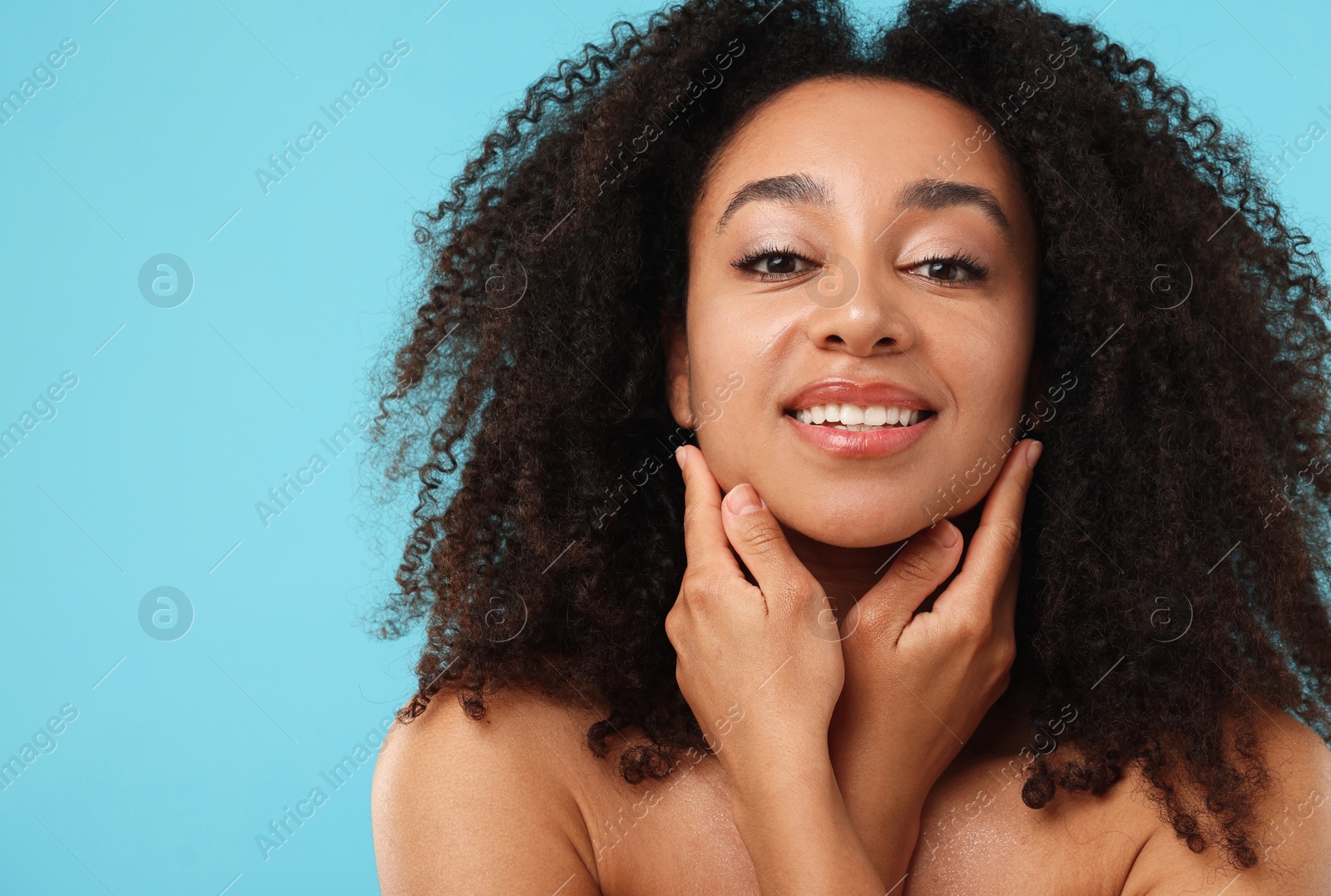 Portrait of beautiful Brazilian woman after spa treatment on light blue background Photo of Portrait of beautiful Brazilian woman after spa treatment on light blue background