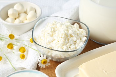 Photo of Fresh dairy products and flowers on table, closeup