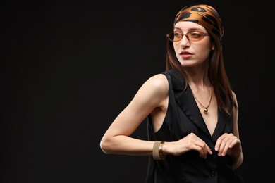 Photo of Portrait of beautiful woman in stylish outfit on black background, space for text