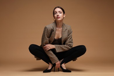 Photo of Full-length portrait of beautiful woman in stylish outfit on beige background