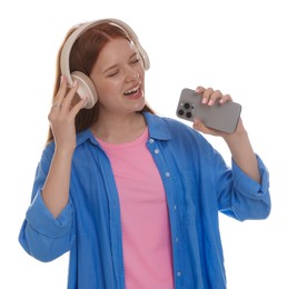 Photo of Happy teenage girl in headphones with smartphone singing on white background