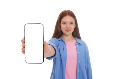 Photo of Beautiful teenage girl showing smartphone with blank screen on white background, selective focus. Mockup for design