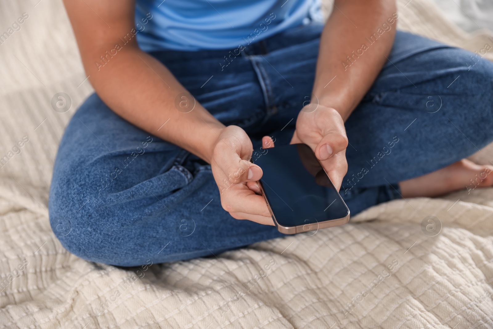 Teenage boy using smartphone on bed at home, closeup Photo of Teenage boy using smartphone on bed at home, closeup