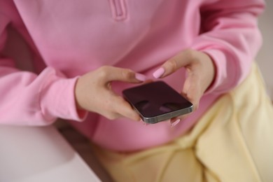 Photo of Teenage girl using smartphone at home, closeup