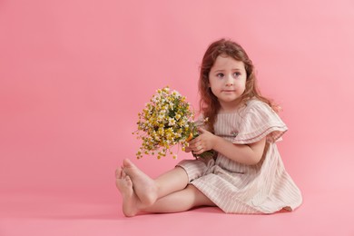 Photo of Cute little girl with bouquet of beautiful chamomile flowers on pink background, space for text
