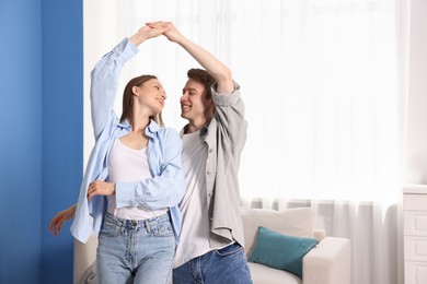 Photo of Happy couple dancing at home. Space for text