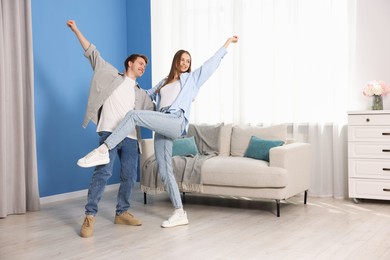 Photo of Happy young couple dancing together at home