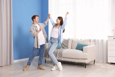 Photo of Happy young couple dancing together at home