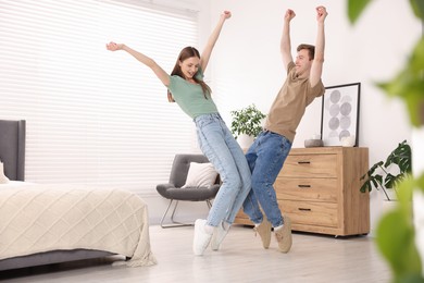 Photo of Happy young couple dancing together at home