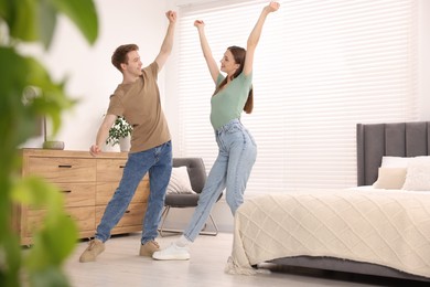 Photo of Happy young couple dancing together in bedroom