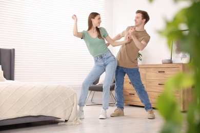 Photo of Happy young couple dancing together at home