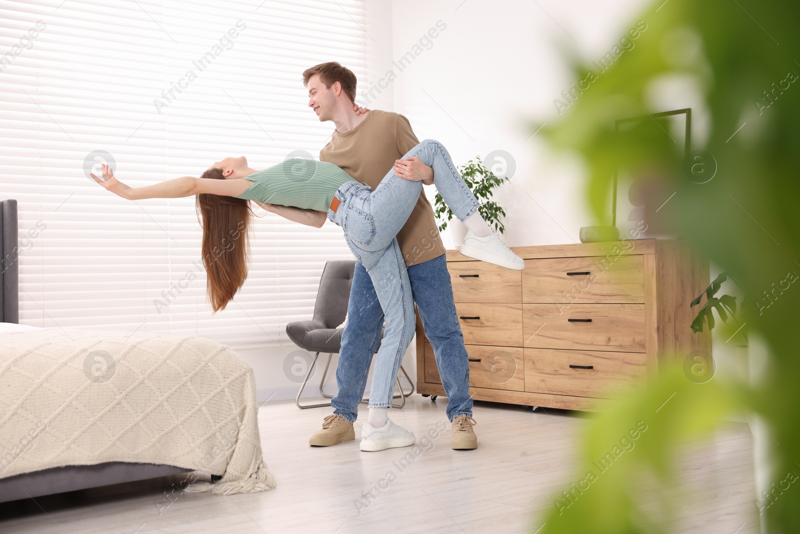 Photo of Happy young couple dancing together at home