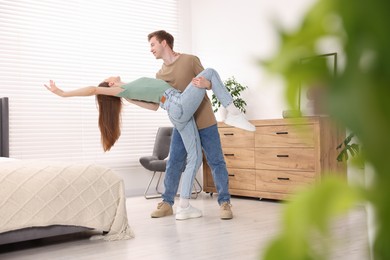 Photo of Happy young couple dancing together at home