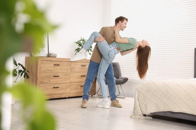 Photo of Happy young couple dancing together at home