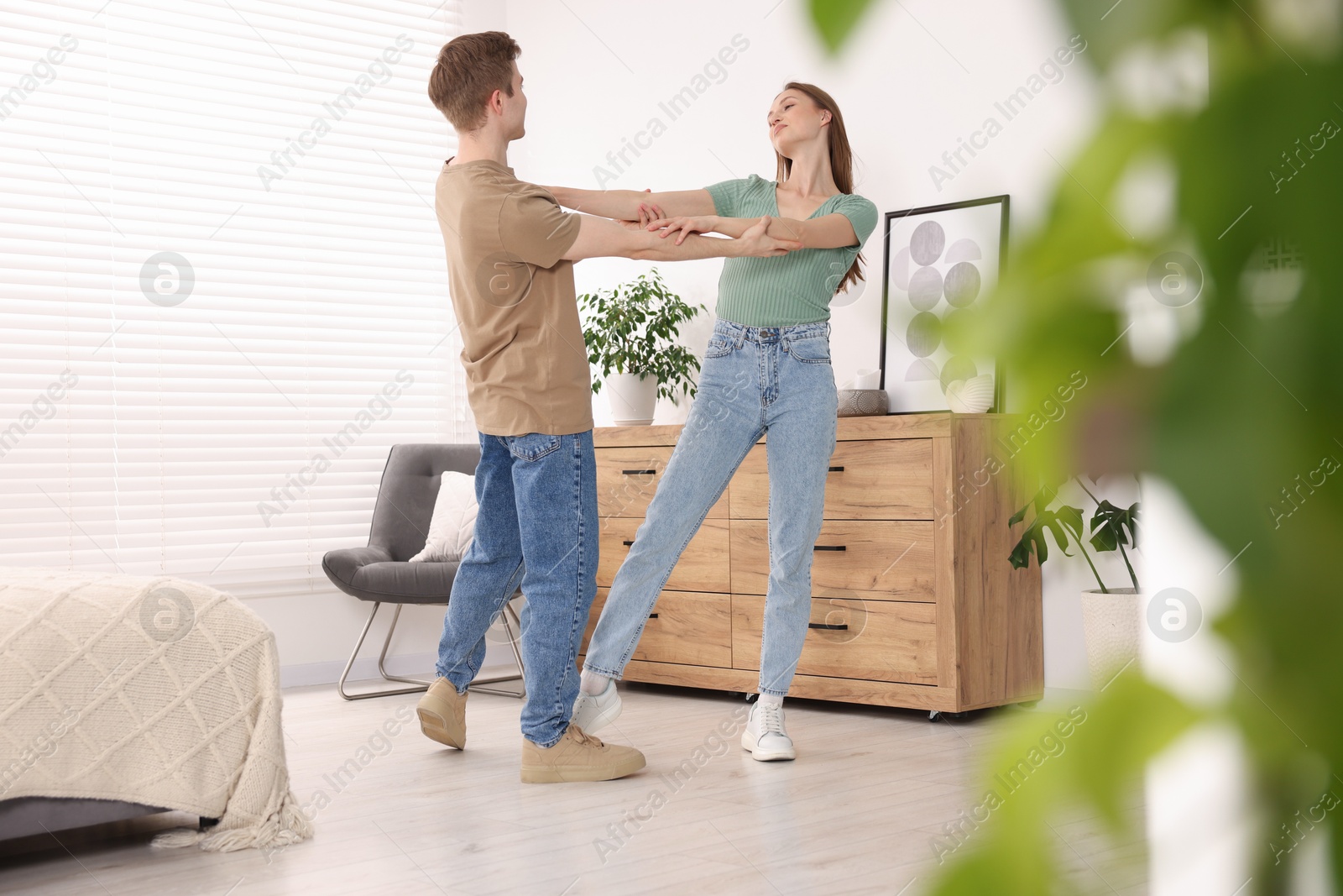 Carefree young couple dancing together at home Photo of Carefree young couple dancing together at home
