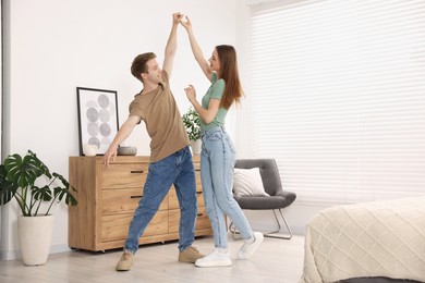 Photo of Happy young couple dancing together at home