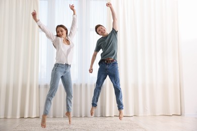 Photo of Happy young couple dancing together at home