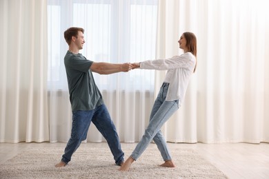Photo of Happy young couple dancing together at home