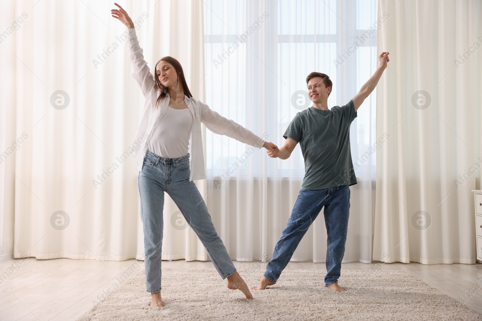 Photo of Happy young couple dancing together at home