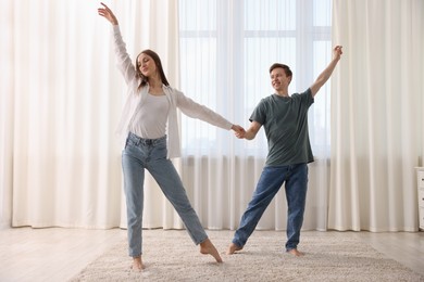 Photo of Happy young couple dancing together at home