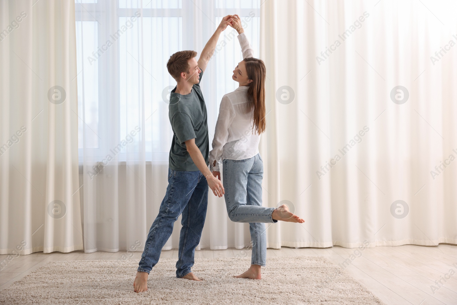 Happy young couple dancing together at home Photo of Happy young couple dancing together at home