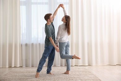 Photo of Happy young couple dancing together at home