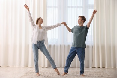 Photo of Happy young couple dancing together at home
